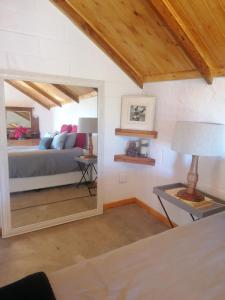 um quarto com uma cama com um espelho e um candeeiro em Amper Bo Farmstead em Sedgefield