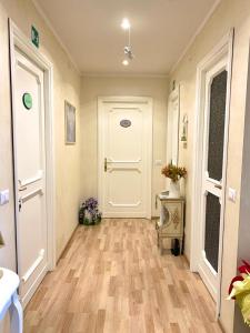 a hallway with a white door and wooden floors at B&B EurGardenie in Rome