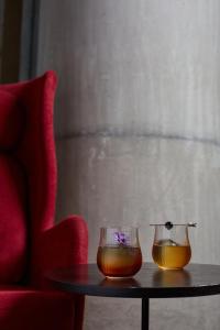 twee glazen schalen op een tafel naast een rode stoel bij Pullman Lima San Isidro in Lima