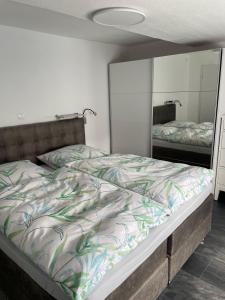 a bedroom with a bed and a mirror at Ferienwohnung-Auszeit in Bad Harzburg