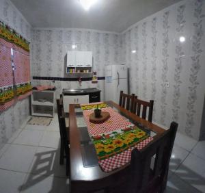 a kitchen with a wooden table and a table and chairs at Hospedagem Casa do Deir in Paraty