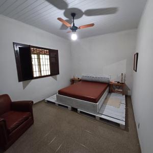 a room with a bed and a ceiling fan at Rancho Leguian in Cachoeiras de Macacu