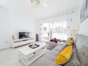 ein Wohnzimmer mit einem grauen Sofa und gelben Kissen in der Unterkunft Cubo's Apartment Alhaurin Golf & Parking in Alhaurín el Grande