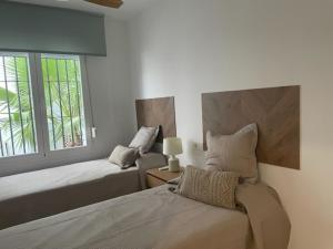 sypialnia z 2 łóżkami i oknem w obiekcie Casa Reserva Los Monteros w Marbelli