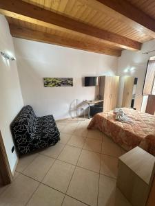 1 dormitorio con 1 cama y 1 silla en una habitación en MANDANICI :Borgo Marsalini 2.0, en Barcellona-Pozzo di Gotto