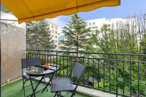 Un balcón con una mesa y sillas en un balcón. en Espace Champerret - 1 Bedroom 4 people, en Levallois-Perret