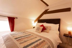 a bedroom with a large bed with a red curtain at Cosy 1 bedroom flat in great central Chester location in Chester