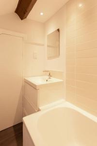 a white bathroom with a sink and a bath tub at Cosy 1 bedroom flat in great central Chester location in Chester