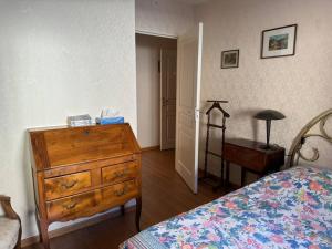 sypialnia z komodą, łóżkiem i stołem w obiekcie Appartement T3 bord de la Vienne w mieście Chinon