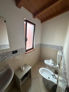 a bathroom with a sink and a toilet and a window at MANDANICI :Borgo Marsalini 2.0 in Barcellona-Pozzo di Gotto