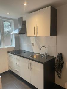 a kitchen with white cabinets and a sink at De Vrije Vogel in Egmond aan Zee