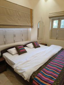 a large white bed with two pillows on it at HERITAGE HAVELI VARANASI in Varanasi