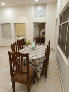 a dining room with a table and chairs and a room with a kitchen at HERITAGE HAVELI VARANASI in Varanasi