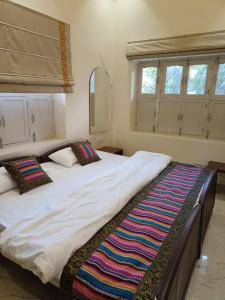 Un pat sau paturi într-o cameră la HERITAGE HAVELI VARANASI