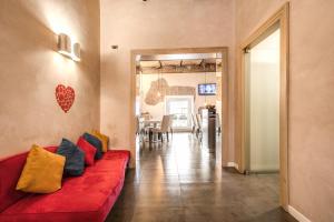 - un salon avec un canapé rouge et des oreillers dans l'établissement Boutique Rome Inn, à Rome