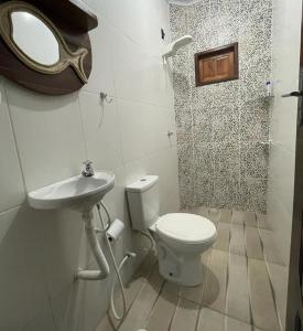 a bathroom with a toilet and a sink and a mirror at Casa beira mar com piscina Coruripe Povoado Miai de cima in Coruripe +71 photos