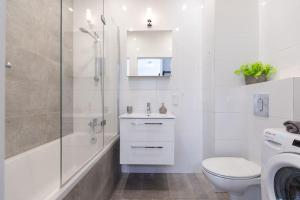 a bathroom with a shower toilet and a sink at Apartament MioMare Letnica Seaside in Gdańsk