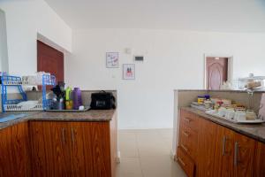 uma cozinha com armários de madeira e uma bancada em Airport Vista Getaway-4km from jomo Kenyatta International Airport em Nairobi