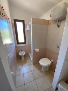a bathroom with a toilet and a shower and a sink at La Collina: Il tramonto in Castiadas