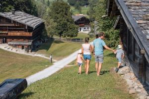 a family walking along a wall of a house at Wiesenhof in Reith im Alpbachtal