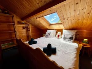 a bedroom with a large bed with a teddy bear on it at Chalet Le Chappoix, 4* avec grand jardin in Granges-sur-Vologne