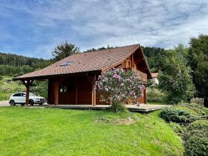 a small cabin with a car parked in front of it at Chalet Le Chappoix, 4* avec grand jardin in Granges-sur-Vologne