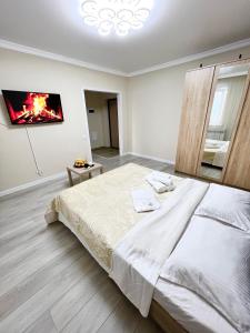 a white bedroom with a large bed and a mirror at Жк sezim Qala in Taldykolʼ