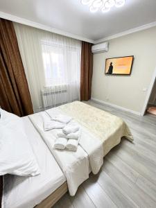 una camera da letto con un letto e asciugamani di Жк sezim Qala a Taldykolʼ