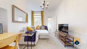 uma sala de estar com um sofá branco e uma televisão em Spacious Cardiff 2-Bed Flat with Parking em Cardiff