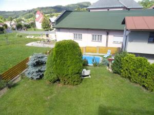 a house with a yard with a swimming pool at Chata SLUKA in Poniklá