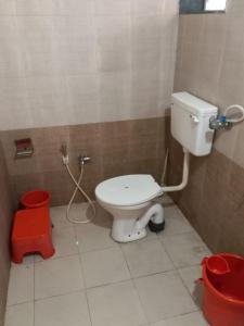 a bathroom with a white toilet in a stall at Swami Leela Relax Inn in Mahabaleshwar