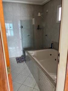 a bathroom with a shower and a bath tub at Apartamento Beira MAr in Guarapari