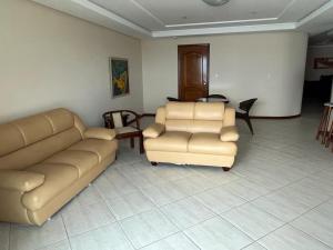 a living room with a couch and two chairs at Apartamento Beira MAr in Guarapari