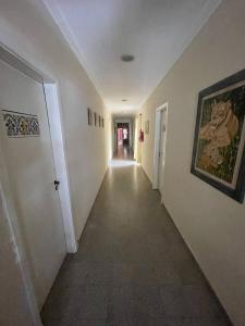 a hallway with white walls and a painting on the wall at Verona Hostel in Necochea