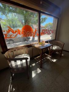 a room with two chairs and a table and a window at Verona Hostel in Necochea