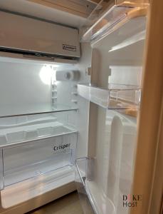 an empty refrigerator with its door open in a kitchen at Duke Vallehermoso Apartament in Madrid