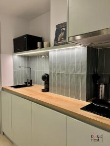 cocina con armarios blancos y encimera en Duke Vallehermoso Apartament en Madrid
