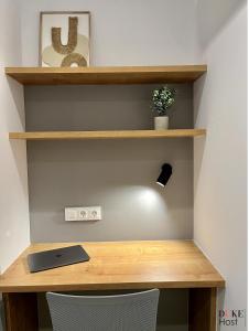 a wooden desk with a laptop on a shelf at Duke Vallehermoso Apartament in Madrid