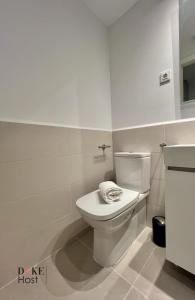 y baño con aseo blanco y lavamanos. en Duke Vallehermoso Apartament en Madrid