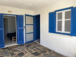 an empty room with blue doors and a window at Ariadne's apartment - Apollonas in Apollon