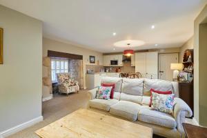 uma sala de estar com um sofá e uma mesa em Host & Stay - Tithe Barn Cottages em Easington