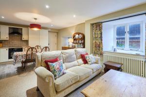 a living room with a couch and a kitchen at Host & Stay - Tithe Barn Cottages in Easington