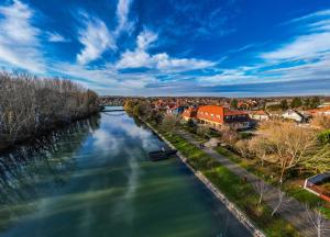 a view of a river with houses and buildings at Regia Panzió in Halászi