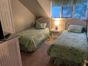 1 dormitorio con 2 camas y mesa con lámpara en Luxury Lake House w/views from every room!, en Huron