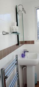ein Bad mit einem Waschbecken und einem Spiegel in der Unterkunft Durham House in Beer
