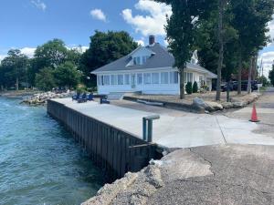 una casa sentada al lado de un cuerpo de agua en Luxury Lake House w/views from every room!, en Huron