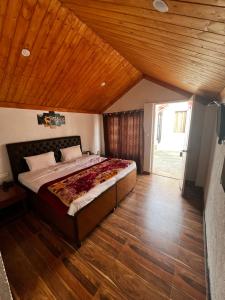 1 dormitorio con 1 cama grande y techo de madera en Nature Nest Resort, en Mai Jūbar