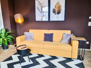 a living room with a yellow couch and blue pillows at maremar - Design Maisonette Altstadt - 4 Personen - Luxus Boxspringbett - Vollausstattung in Greiz