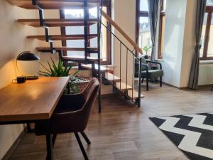 ein Wohnzimmer mit einem Holztisch und einer Treppe in der Unterkunft maremar - Design Maisonette Altstadt - 4 Personen - Luxus Boxspringbett - Vollausstattung in Greiz