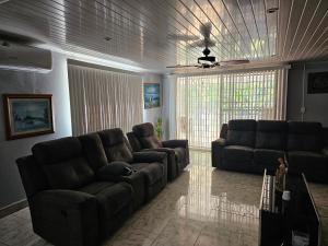 a living room with two couches and a couch at oasis with pool near Panama Canal in Panama City